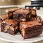Decadent 2 Ingredient Reese's Brownies with a rich chocolate layer and creamy peanut butter swirls on a white plate.