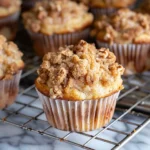 Golden-brown Banana Walnut Streusel Muffins topped with buttery walnut cinnamon crumb on a cooling rack, showcasing crumbly texture and inviting homemade appearance.