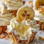 Golden mini banana cream pies with fluffy whipped cream, honey drizzle, and banana slices atop crisp graham crust, artfully arranged for a stunning presentation.