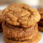 Golden brown Perfect Pumpkin Spice Cookies stacked on a white plate, coated with shimmering cinnamon-sugar, featuring soft chewy centers and slightly crisp edges for a cozy, appealing autumn treat.