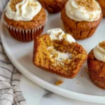 Soft, golden Quick Gluten-Free Pumpkin Cream Cheese Muffins with creamy swirled centers and fluffy texture, beautifully arranged on a white plate.