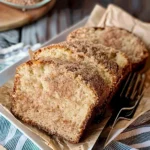 Moist Snickerdoodle Zucchini Bread slices topped with cinnamon-sugar crust, showing golden edges and soft, marbled crumb on a white platter.