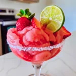 Glorious Frozen Strawberry Margarita Slush in a salt-rimmed glass, topped with fresh strawberries and a lime wheel, showcasing bright pink, frosty, creamy swirls.