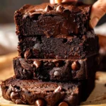 Moist Chocolate Pumpkin Bread with melty chocolate chips, deep brown color, and a glossy, rich texture stacked in thick, tempting slices on parchment paper.