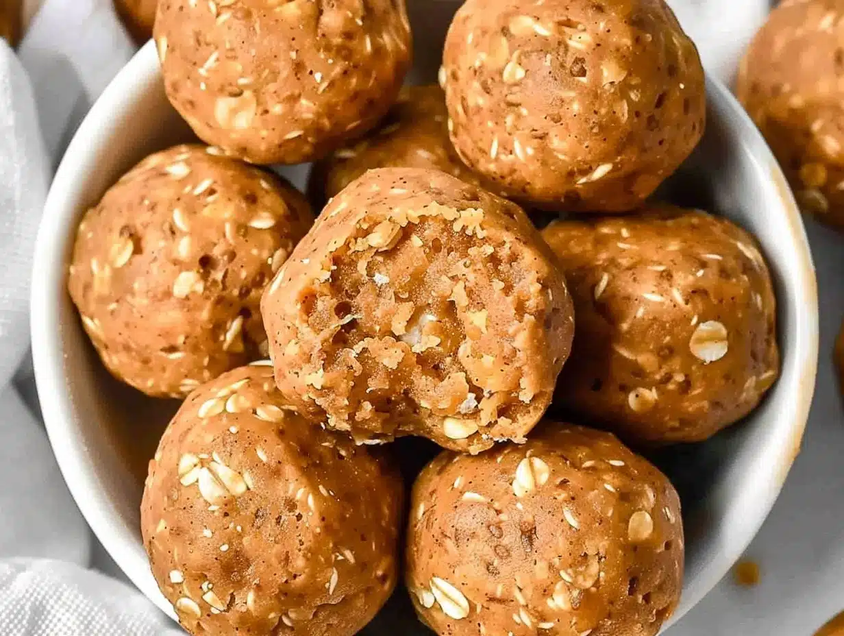 Golden pumpkin protein balls with visible oats, arranged in a white bowl, featuring soft chewy texture and rich orange hue for an inviting, wholesome snack