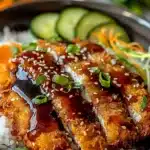 Close-up of Japanese Katsu Bowls with crispy fried chicken, tonkatsu sauce, sushi rice, green onions, and fresh cucumber slices