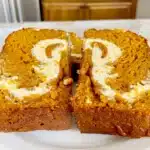 Close-up of moist pumpkin bread sliced to show creamy cream cheese swirl perfect for autumn treats