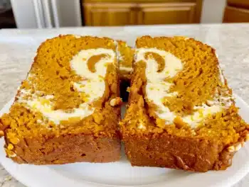 Close-up of moist pumpkin bread sliced to show creamy cream cheese swirl perfect for autumn treats
