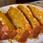 Sliced Classic Spiced Pumpkin Bread on a white plate showcasing warm spices and moist texture
