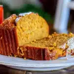 Moist sliced pumpkin bread made with canned pumpkin and warm spices on a white plate.