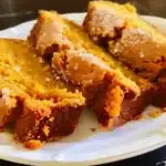 Slices of moist pumpkin bread made with creamy pumpkin pie filling on a white plate