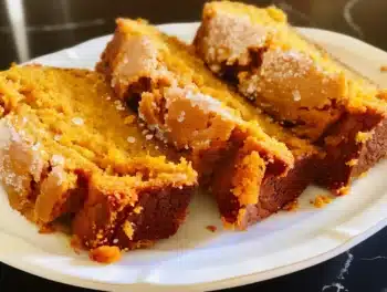 Slices of moist pumpkin bread made with creamy pumpkin pie filling on a white plate
