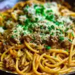 Creamy three-cheese parmesan Cajun beef spaghetti garnished with fresh parsley