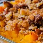 Close-up of delicious Ruth's Chris Sweet Potato Casserole topped with crunchy pecans in a glass baking dish